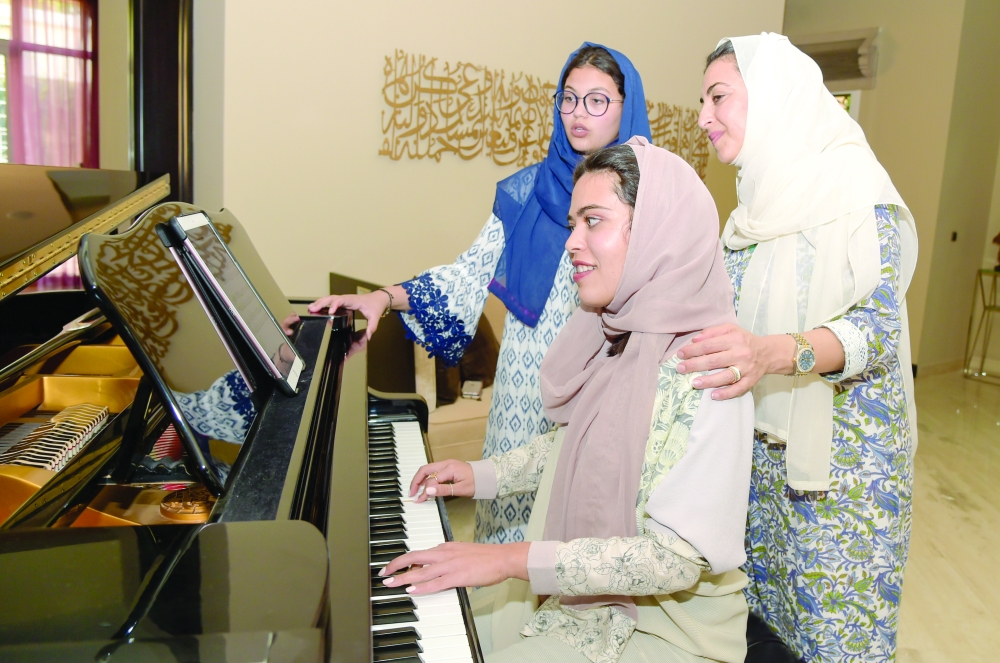 دانية قزاز مع ابنتها كارين وابنتها ندى يعزفن على البيانو