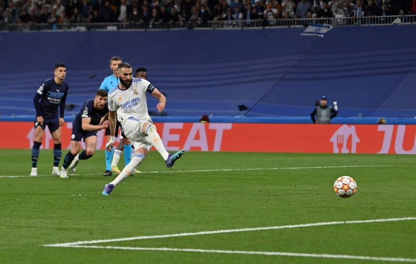 Real Madrid's French striker Karim Benzema scores the team's third goal from the penalty spot during the UEFA Champions League semi-final second leg football match between Real Madrid CF and Manchester City at the Santiago Bernabeu stadium in Madrid on May 4, 2022. (Photo by Paul ELLIS / AFP)