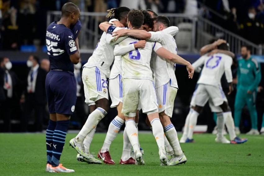 Real Madrid's players celebrate after winning the UEFA Champions League semi-final second leg football match between Real Madrid CF and Manchester City at the Santiago Bernabeu stadium in Madrid on May 4, 2022. (Photo by JAVIER SORIANO / AFP)