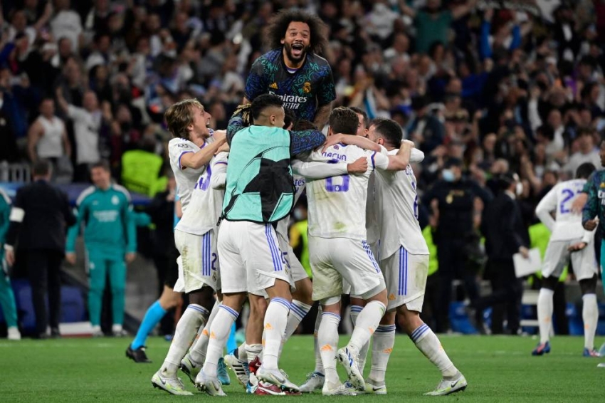 Real Madrid's Brazilian defender Marcelo (Top) celebrates with teammates at the end of the UEFA Champions League semi-final second leg football match between Real Madrid CF and Manchester City at the Santiago Bernabeu stadium in Madrid on May 4, 2022. (Photo by JAVIER SORIANO / AFP)