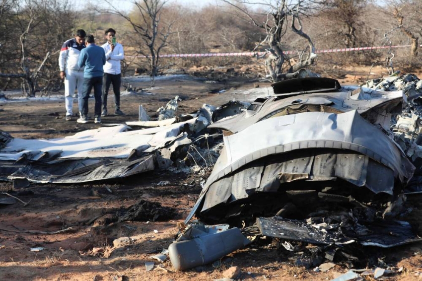 People stand next to a plane wreckage after a Sukhoi Su-30 and a Dassault Mirage 2000 fighter jets crashed during an exercise in Pahadgarh area some 50 kilometres (30 miles) from Gwailor on January 28, 2023. - Two Indian Air Force fighter jets crashed on January 28 in an apparent mid-air collision while on exercises around 300 kilometres (185 miles) south of the capital New Delhi, police at the crash site told AFP. (Photo by AFP)
