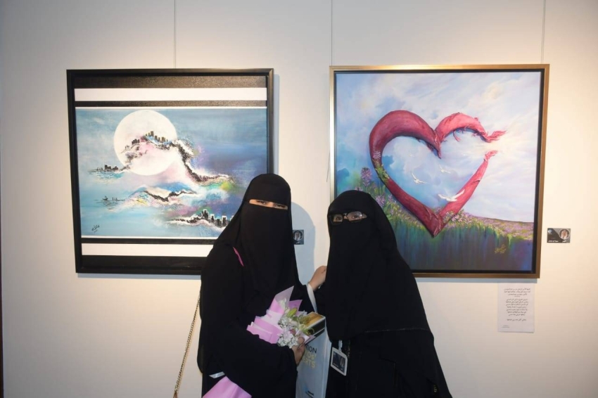 الفنانتان نجلاء أحمد وسمية أبو سليمان مع لوحتيهما بمعرض «البدر»